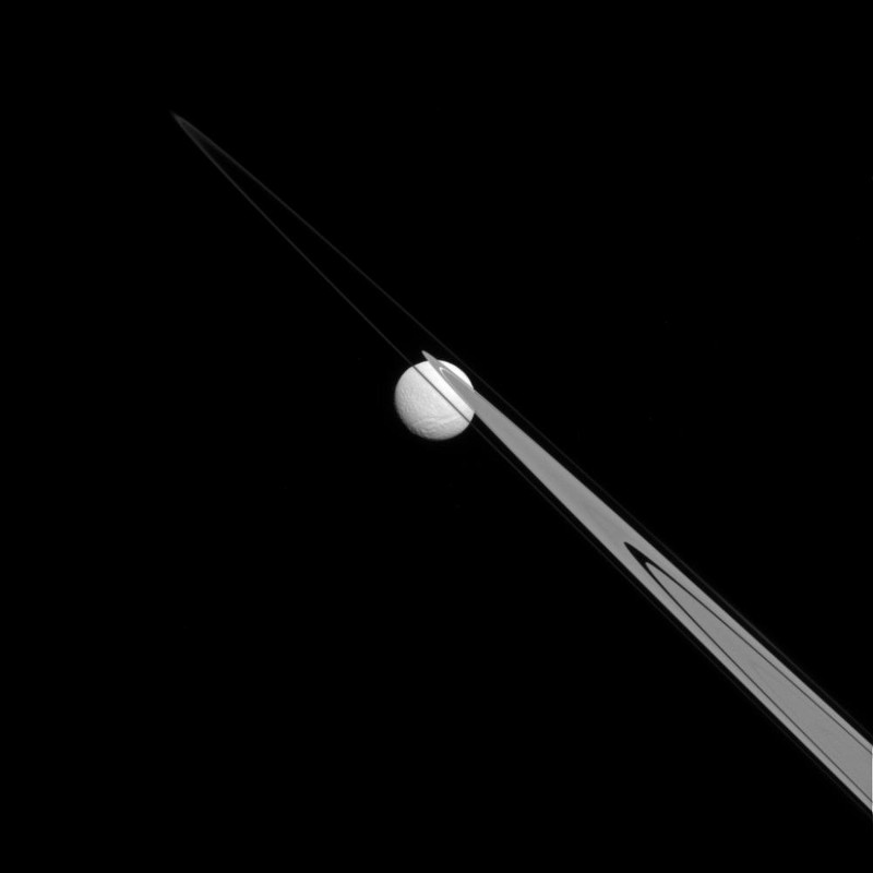 Saturn's moon Tethys, hanging from on its rings