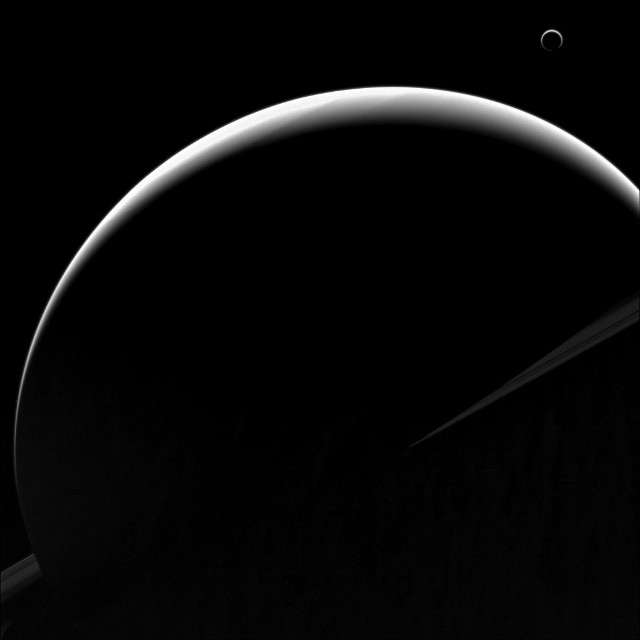 Saturn and Titan are in shadows, showing a crescent phase